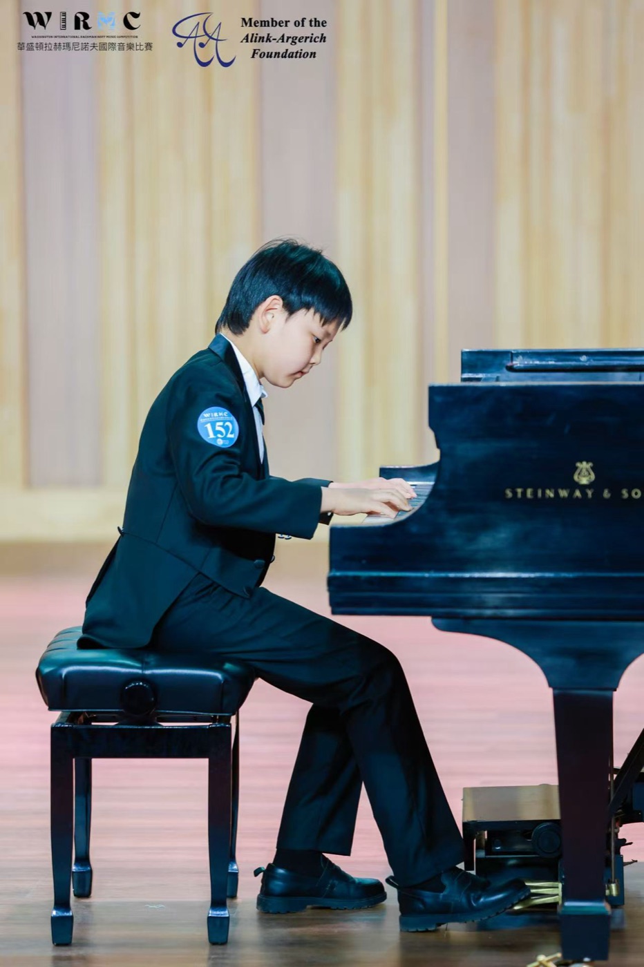 Alan Wang playing a Steinway grand piano on stage